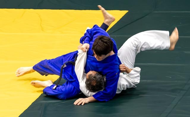 Two judoka transitioning into groundwork