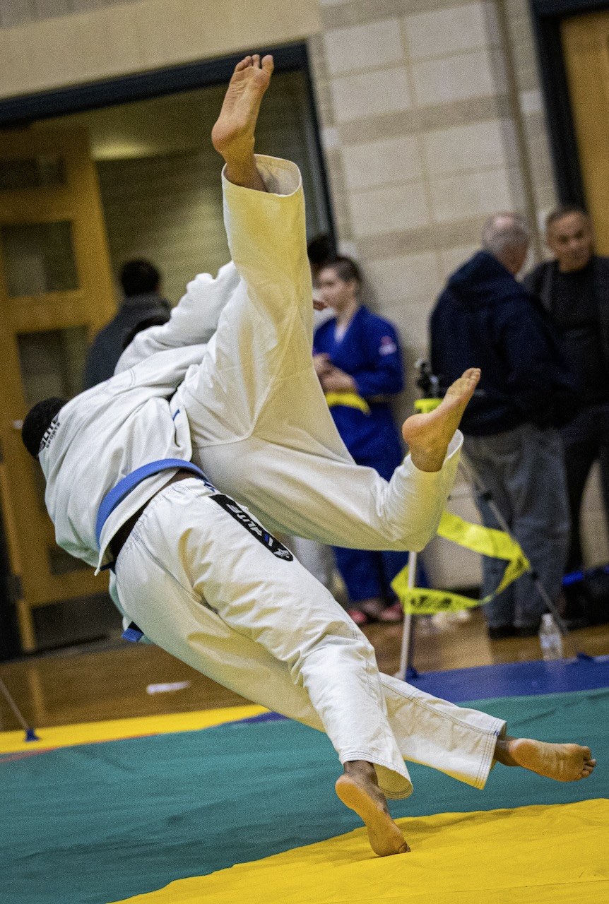 Two judoka completing a standing throw
